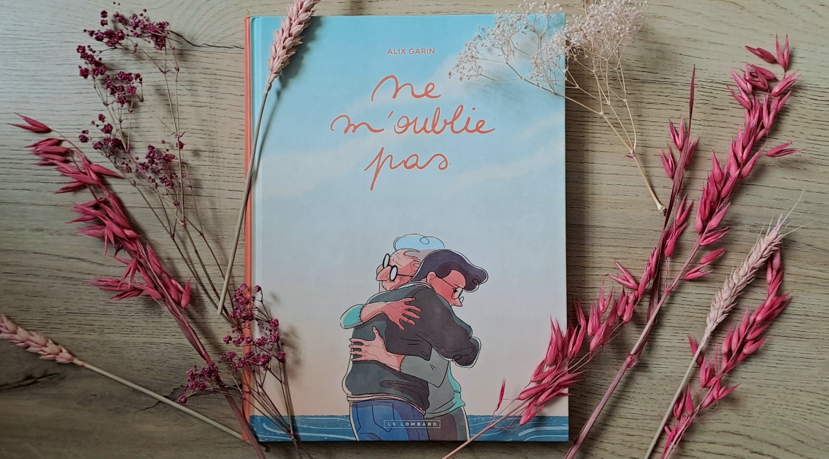 Photo de la BD, installée sur le sol avec des fleurs séchées rose qui l'entoure