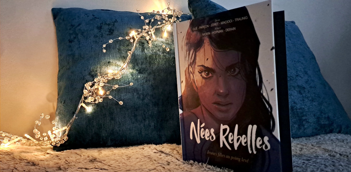 Photo du livre sur un canapé avec une guirlande lumineuse en arrière plan